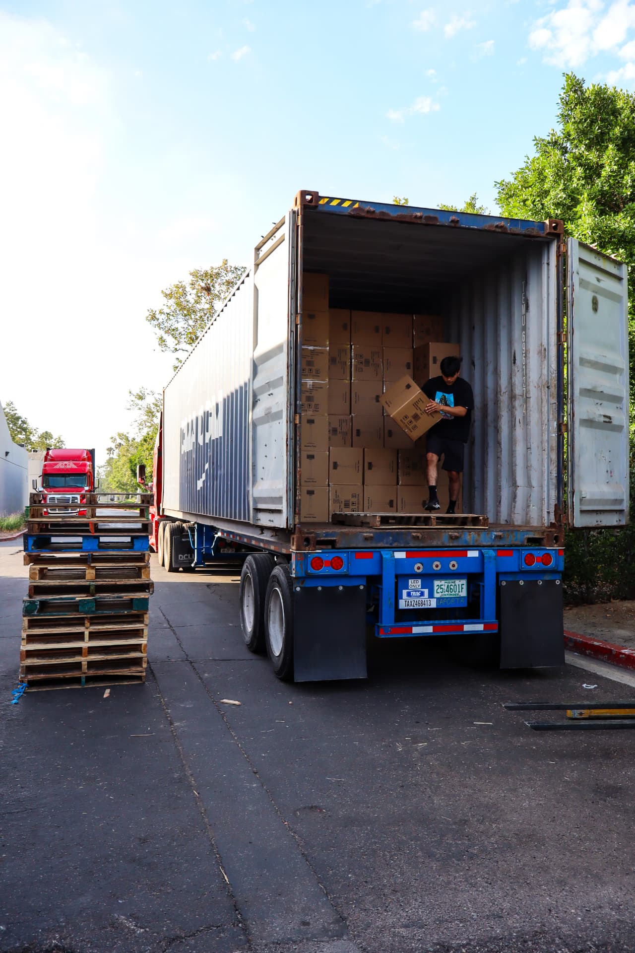 A team member unloading cartons from a shipping container