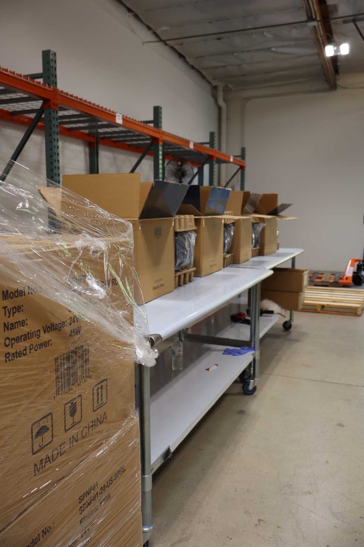Open product cartons arranged along an assembly table