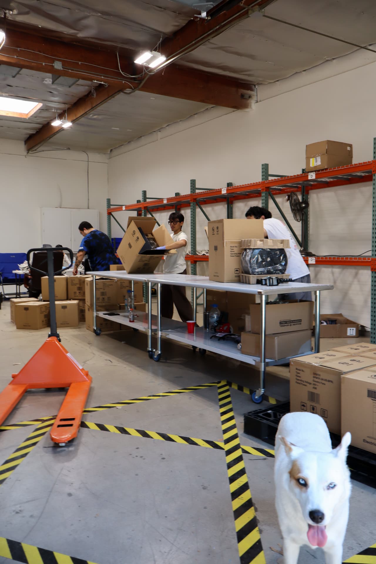 Team members working with product cartons at warehouse packing tables
